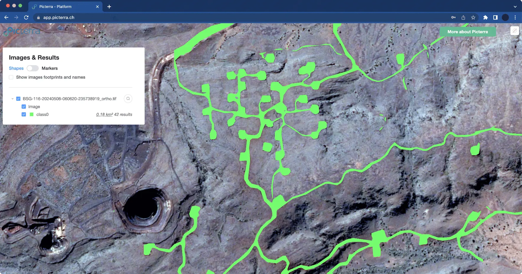 An aerial satellite view, processed with the Picterra geospatial platform, of a rocky, arid mining landscape is presented. A central area features a cluster of bright green polygons, each about 0.01 hectares, connected by green line segments. In the upper left-hand corner, an "Images & Results" panel displays a list of layers, including a checked "Image" layer and a checked "class0" layer with 42 results, along with options for "Shapes," "Markers," and "Show images footprints and names." A large open-pit mine is visible on the left side, and a "More about Picterra" button is situated in the upper right-hand corner.