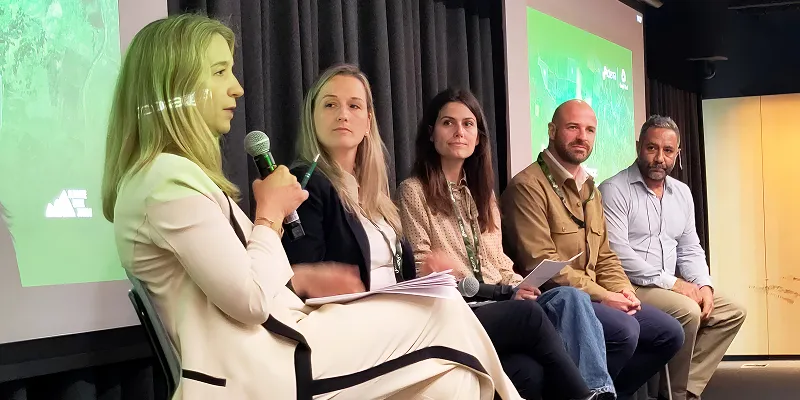 Photo from Climate Week Zurich showing a panel discussion with five speakers seated on stage, discussing climate risk and supply chain resilience.